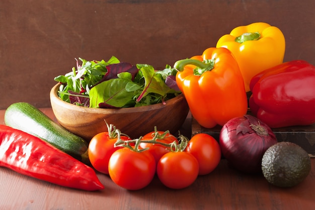 Healthy vegetables pepper tomato salad onion avocado on rustic table