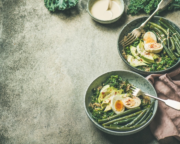 Healthy vegetarian breakfast bowls over concrete background copy space