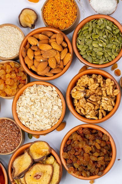 Healthy vegetarian food concept Assortment of dried fruits nuts and seeds on white background