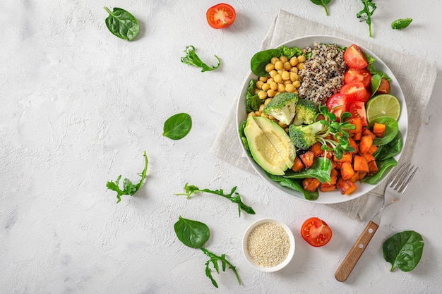 Концепция здорового вегетарианского питания: киноа с овощами, семенами и травами на белом фоне. Вид сверху.