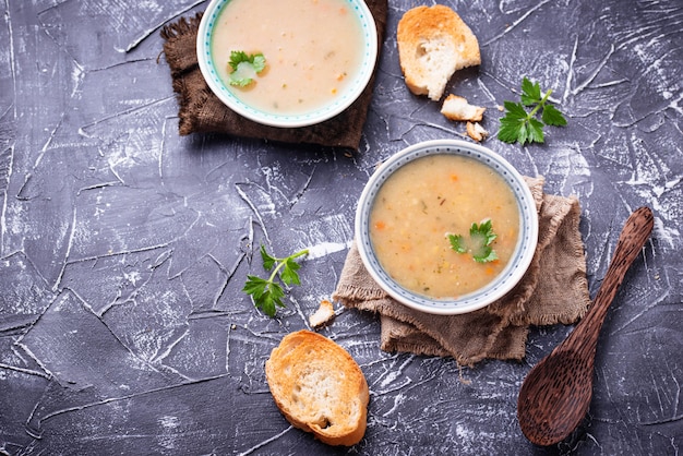 Healthy vegetarian peas soup on concrete background