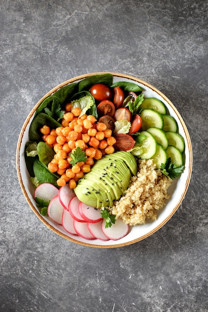 Foto una sana insalata vegetariana con ceci, quinoa, cetrioli, ravanelli e avocado