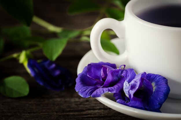 Photo healthy water pea flowers juice placed on the old wood background