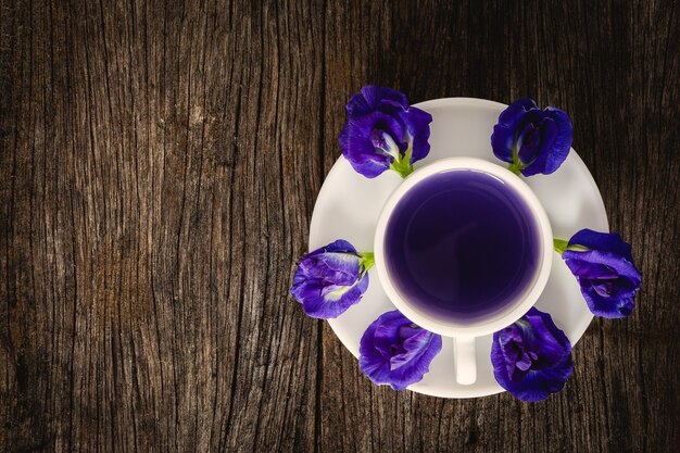 Photo healthy water pea flowers juice placed on the old wood background