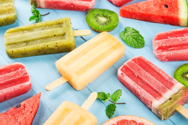 Healthy Whole Fruit Popsicles with Berries Kiwi watermelon cantaloupe on wooden vintage table