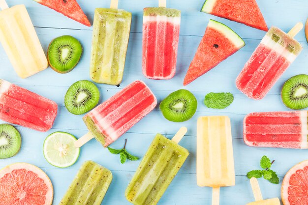 Healthy Whole Fruit Popsicles with Berries Kiwi watermelon cantaloupe on wooden vintage table