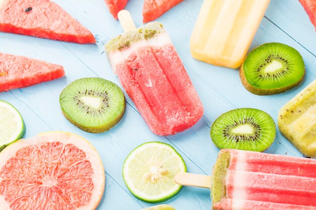 Healthy Whole Fruit Popsicles with Berries Kiwi watermelon cantaloupe on wooden vintage table