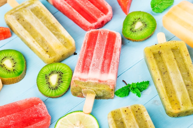 Healthy Whole Fruit Popsicles with Berries Kiwi watermelon cantaloupe on wooden vintage table