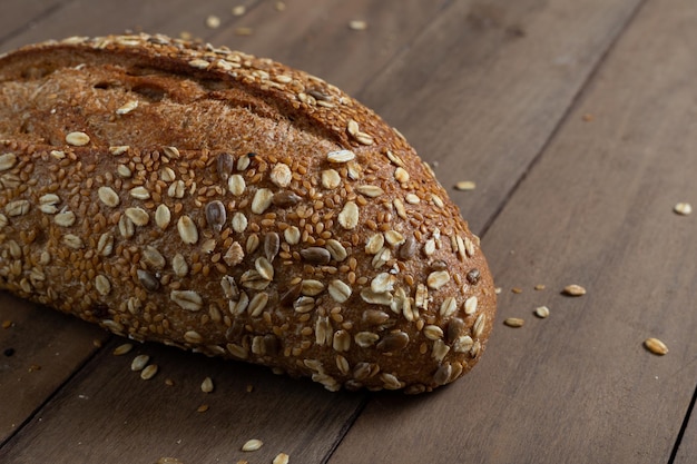 Pane integrale sano della pagnotta artigianale su uno spazio della copia del tavolo di legno