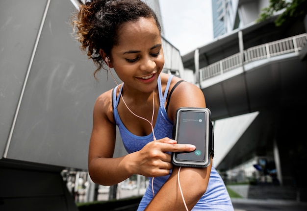 Foto donna in buona salute che si esercita mentre usando tecnologia