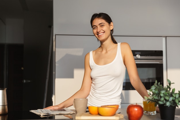 Здоровая женщина на кухне, стоя повседневной утренней рутины.
