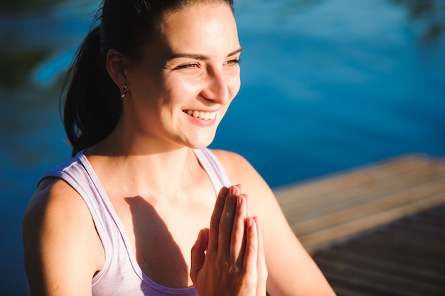 Здоровый образ жизни женщины сбалансированы практикующих медитировать и энергии йоги на мосту в утренней природе.
