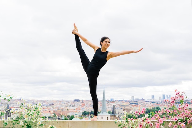 Healthy woman in sportswear practicing yoga outdoor, doing exercise, full length portrait.