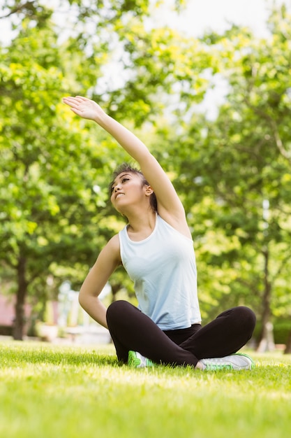 Healthy woman stretching hand in park