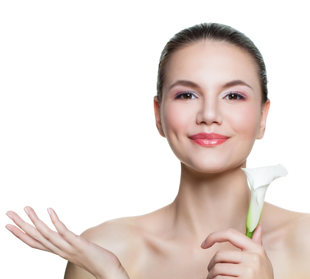 Healthy woman with clear skin and flower showing empty copy space on the open hand isolated on white background Skin care and spa concept