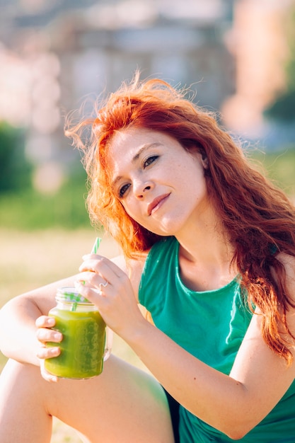 Healthy woman with green vitamins juice