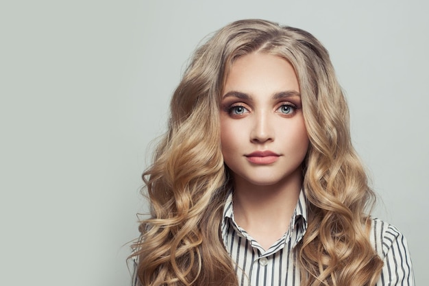 Healthy woman with long curly blonde hairstyle on white