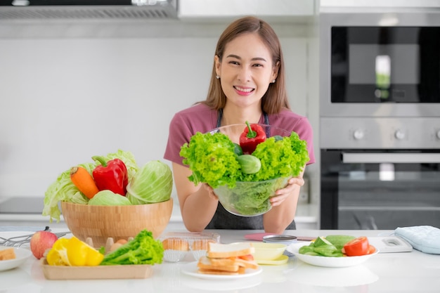 サラダ野菜を調理する健康な女性は朝食を食べる