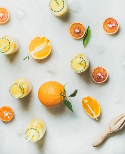 Healthy yellow smoothie with citrus fruit ginger ice in bottles