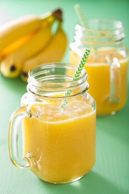 Healthy yellow smoothie with mango pineapple banana in mason jars