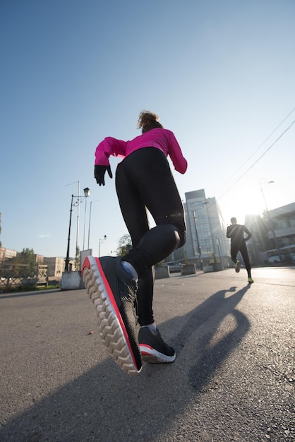 healthy young  couple jogging in the city  at early morning with sunrise in background