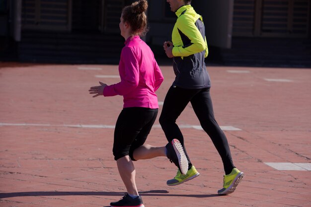 healthy young  couple jogging in the city  at early morning with sunrise in background