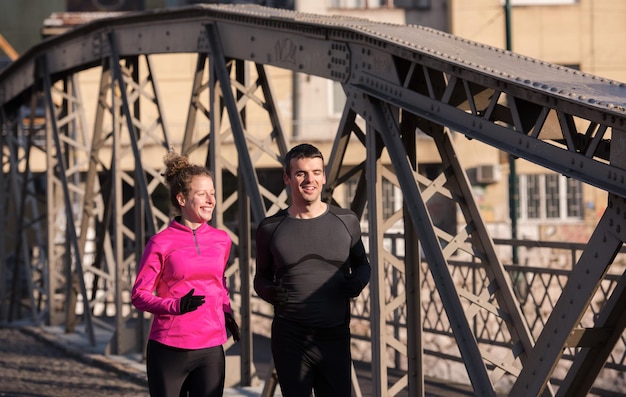 healthy young  couple jogging in the city  at early morning with sunrise in background