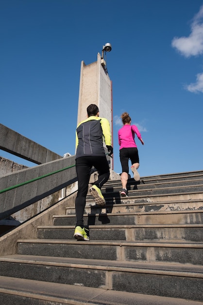 healthy young  couple jogging on steps  at early morning