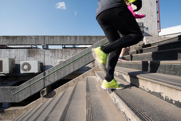 healthy young  couple jogging on steps  at early morning