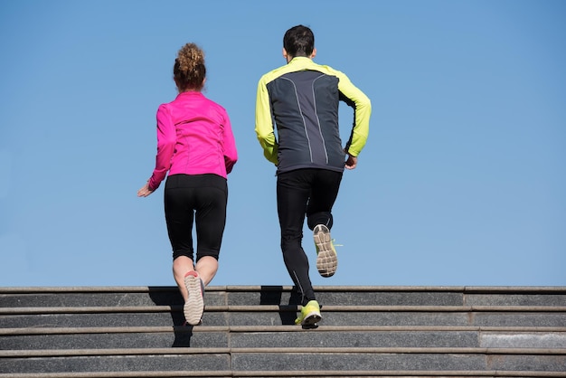 healthy young  couple jogging on steps  at early morning