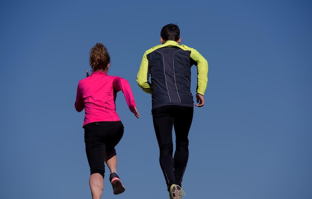 healthy young  couple jogging on steps  at early morning