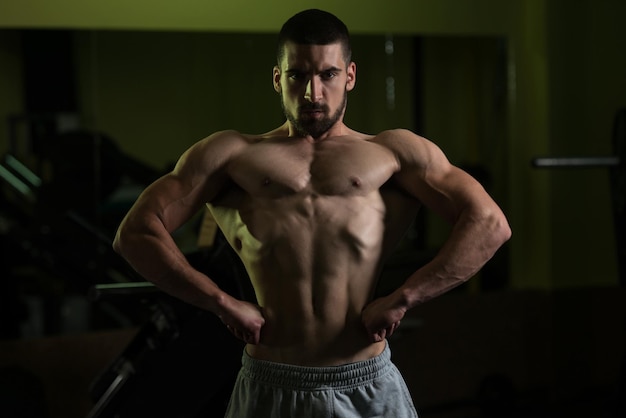 Photo healthy young man flexing muscles