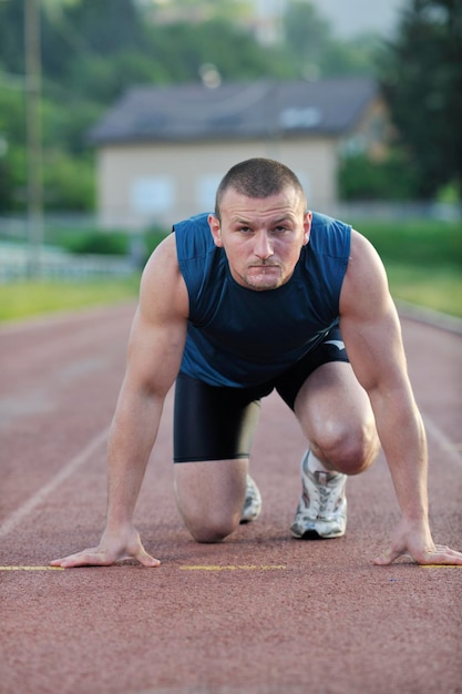 実行レースと勝利の準備ができてスタートラインで健康な若い男