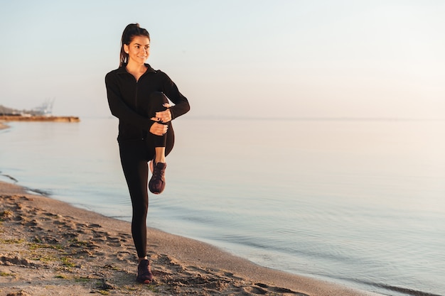 Healthy young sportswoman doing stretching exercises