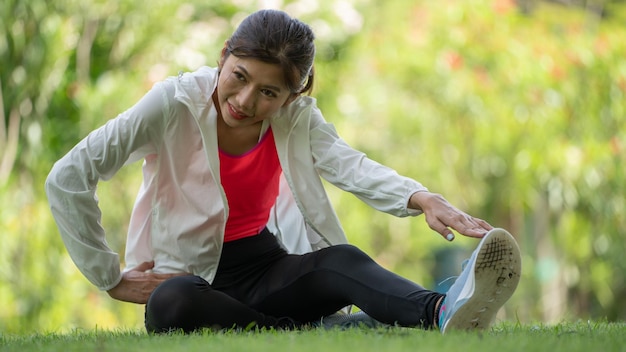 Здоровая молодая женщина тренируется перед бегом или фитнес-тренировкой в городском парке