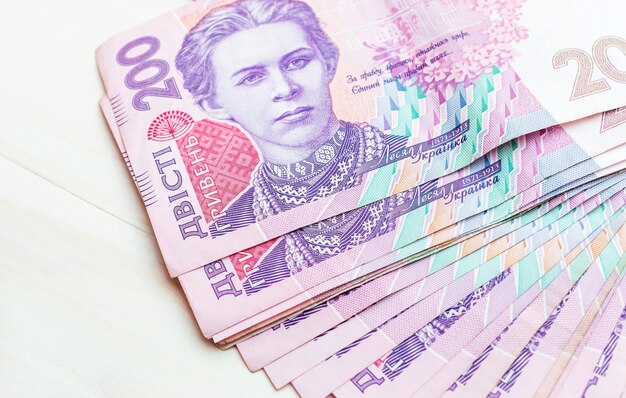 Heap of 200 ukrainian hryvnia bills on white table Copy space