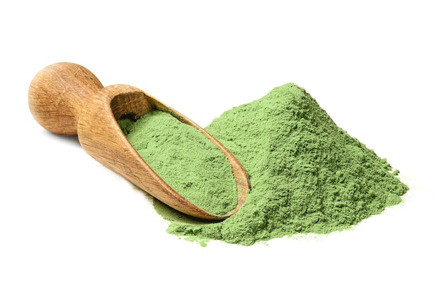 Heap of Barley grass green powder with wodden shovel detox superfood