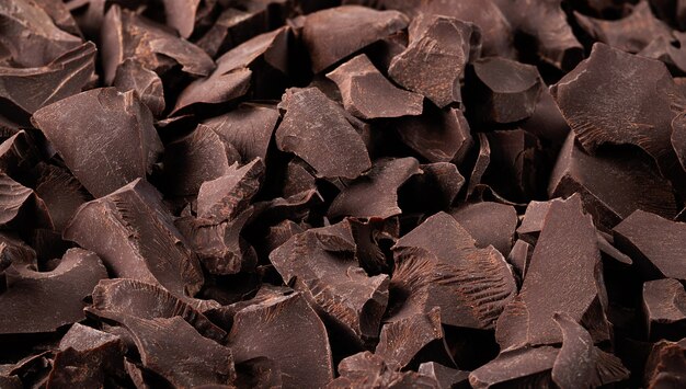 Heap of broken bitter chocolate, dessert food background