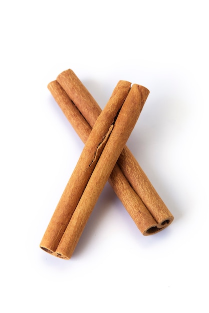 A heap of cinnamon sticks on white surface