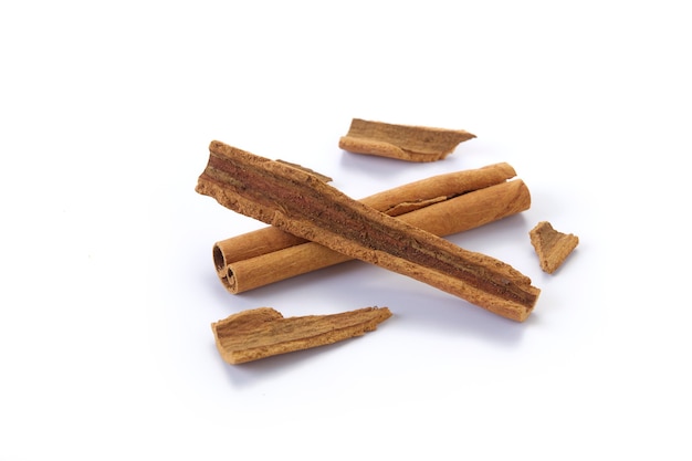 A heap of cinnamon sticks on white surface
