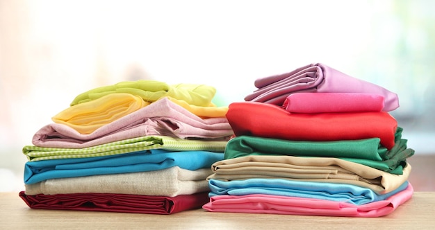 Heap of cloth fabrics on wooden table