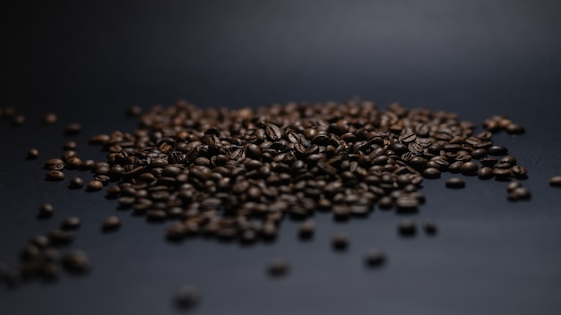 Heap of coffee beans on black background. Coffee beans pile isolated on black background. Culinary coffee background.