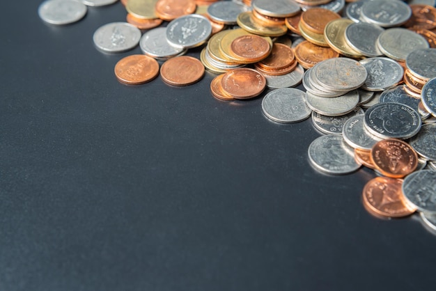 Heap coins on black table with space