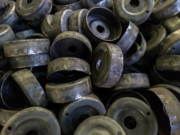 Photo heap of dirty black stamped metal round shells after a hood operation