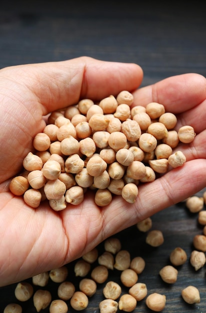 Photo heap of dried chickpeas in hands an excellent source of plant protein