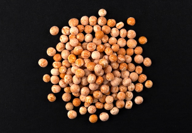 Heap of dried yellow pea isolated on black