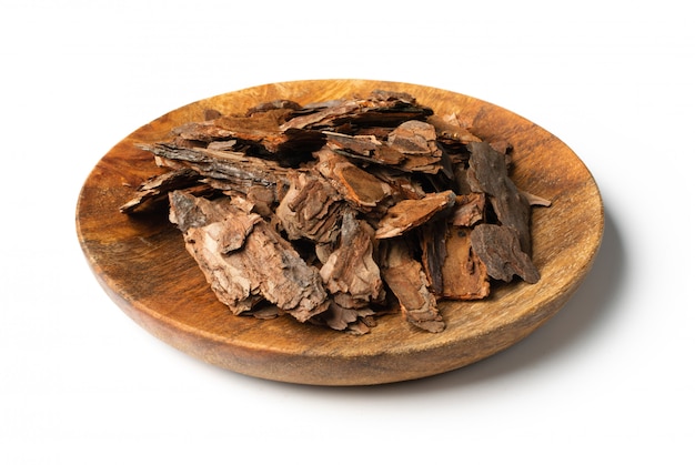 Heap of Dry Pine Tree Bark Pieces on Wood Plate Isolated on White. Broken Woods Nature Chip