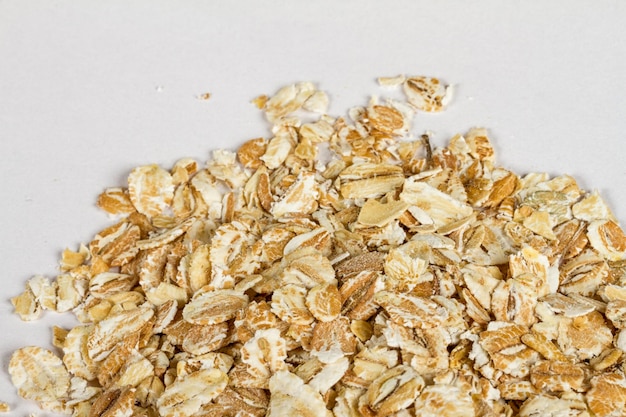 Heap of dry rolled oats isolated on white background