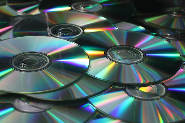 Heap of DVD CD disks on white