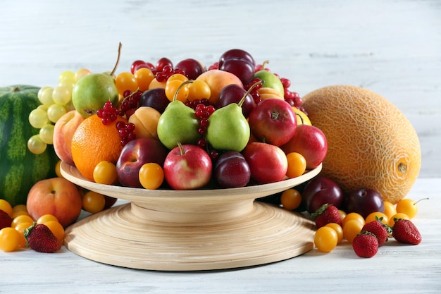 Heap of fresh fruits and berries on wooden background